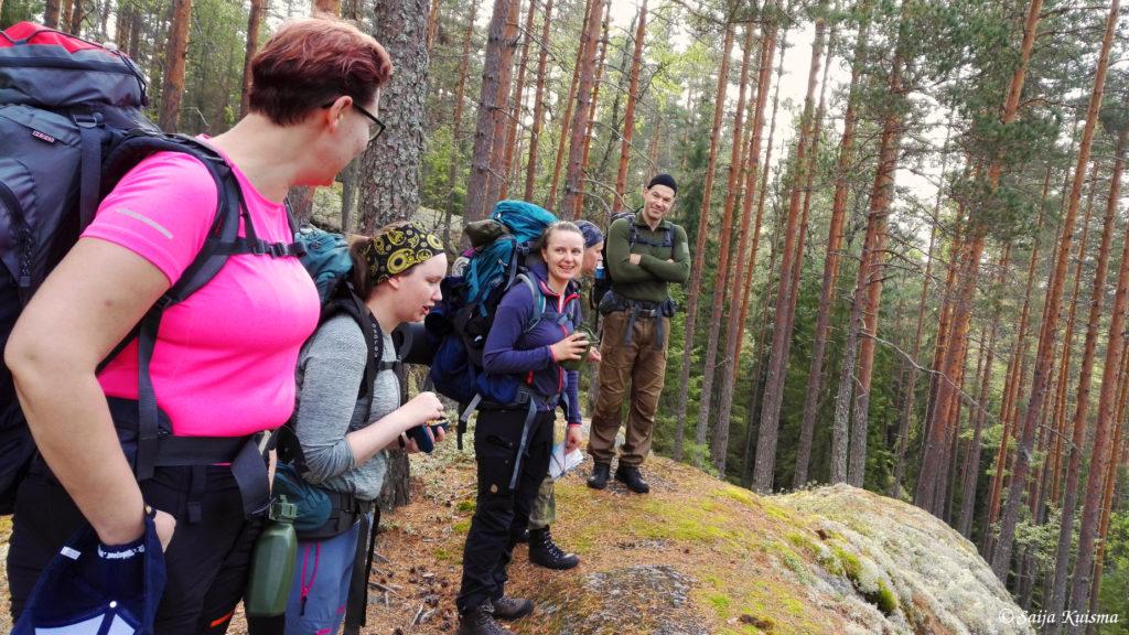 Kuva naisia ja miehiä rinkat selässä maastovaelluksella.