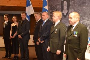 Kuva henkilöistä jotka saivat plaketin vaakuna-alustalla.