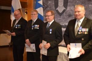 Kuva neljästä miehestä jotka saivat hopeisen ansiomitalin.