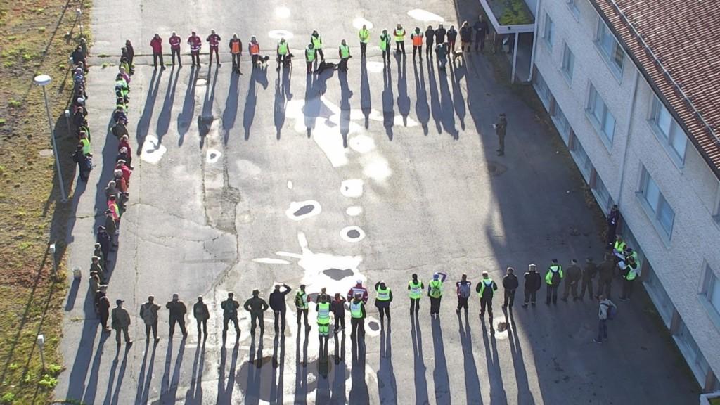Ilmakuvassa harjoituksen osallistujia koolla rakennuksen pihalla.