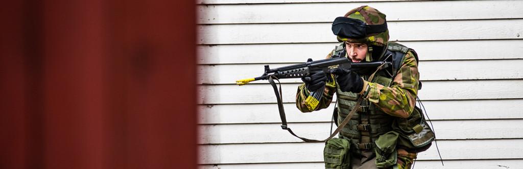 Reserviläinen etenee oikealta vasemmalle ase ylävalmiusotteessa.