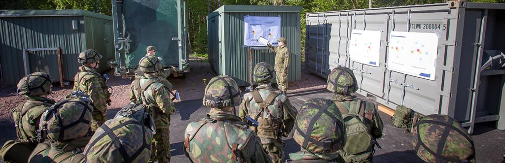 Vapaaehtoinen reserviläiskouluttaja opettaa toisia reserviläisiä ulkona.