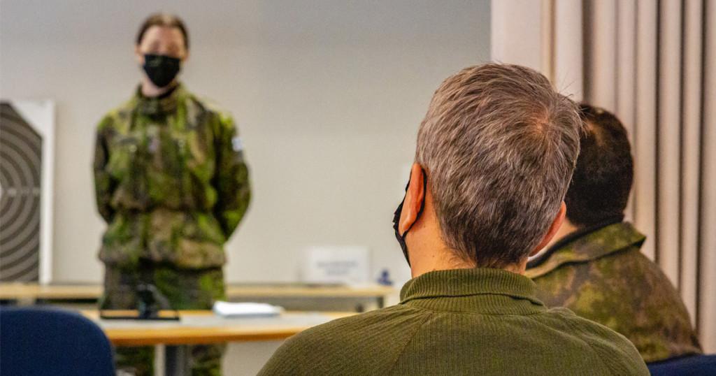 MPK:n kurssilainen istuu oppitunnilla selin kameraan päin. Kuvan henkilöillä on kasvomaskit.