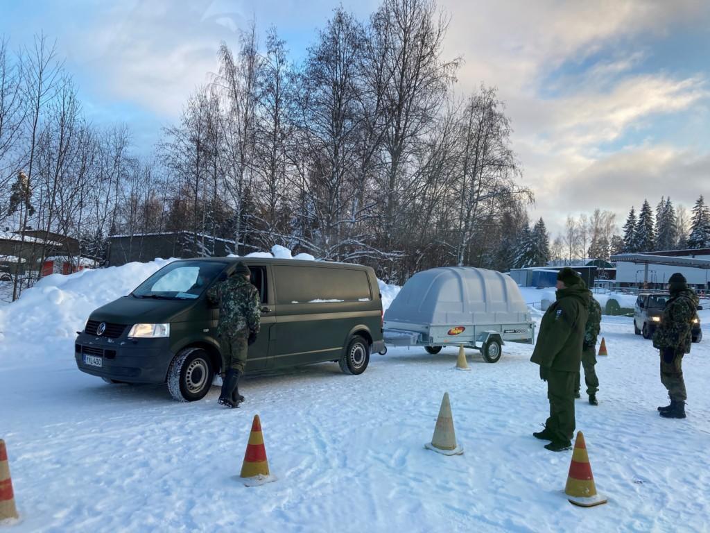 Ihmisiä ulkona pakettiauton, jossa peräkärry ja keilojen ympärillä