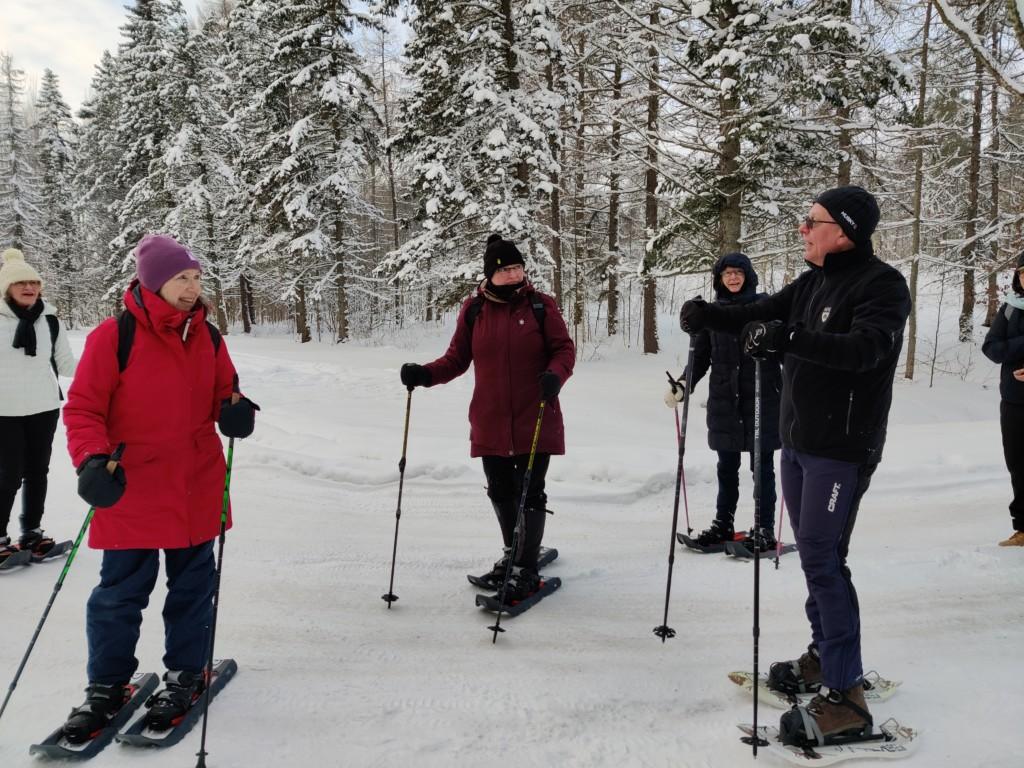 naisia lumikengissä tiellä kuuntelemassa miesopettajaa