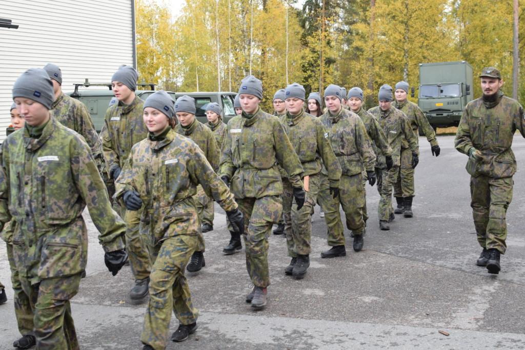 Nuoria kävelemässä maastopuvut päällä kurssilla