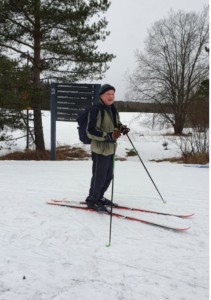 Mies seisoo ladun vieressä tyytyväisenä