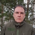 Mies maastopuvussa ulkona
