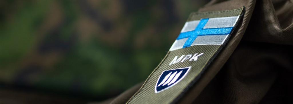 MPK:n hihamerkki kenttäasun hihassa. Taustalla maastokuvio M05.
