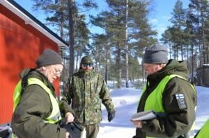 mies haastateltavana, kaksi naista valmistautuu haastatteluun