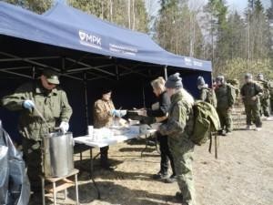 Ihmisiä ruokajonossa ulkona maastopuvut päällä