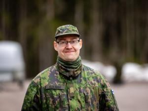 Mies maastoasussa ulkona