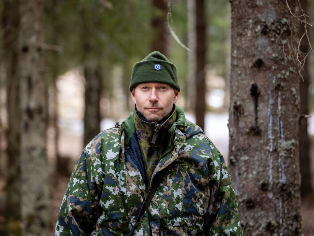 Mies metsässä maastopuvussa