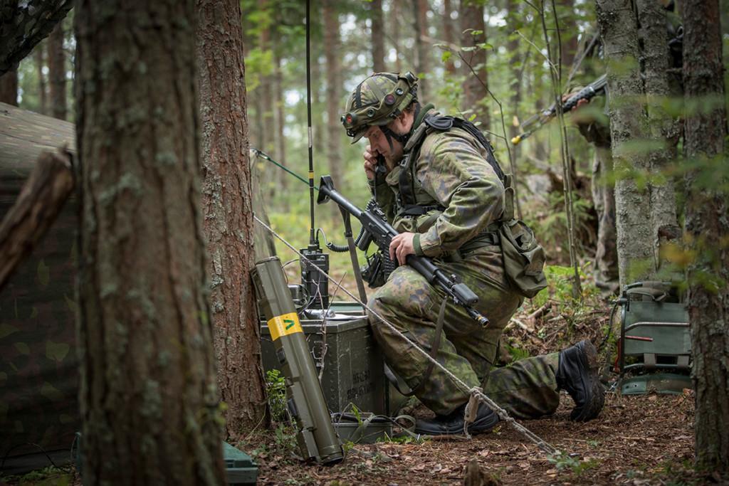 Taistelija käyttää kenttäradiota metsässä.