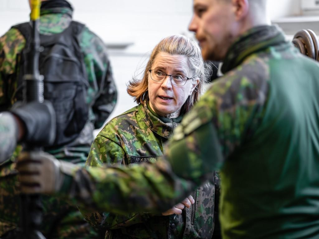 Nainen ja mies maastopuvuissa rakennuksen sisällä