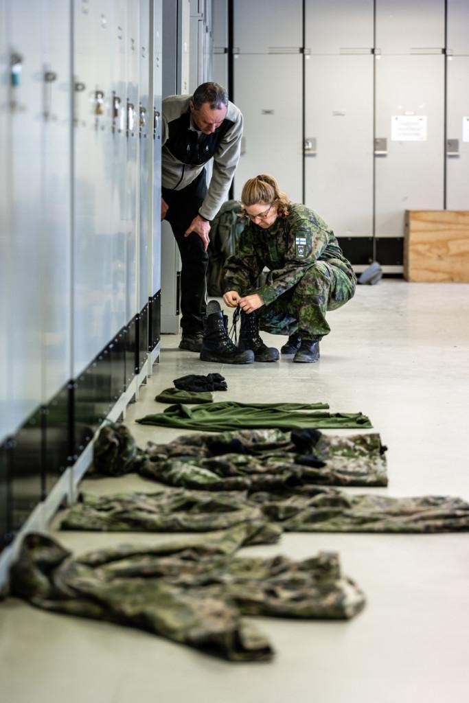 Mies ja nainen järjestelee maastopukuja lattialla