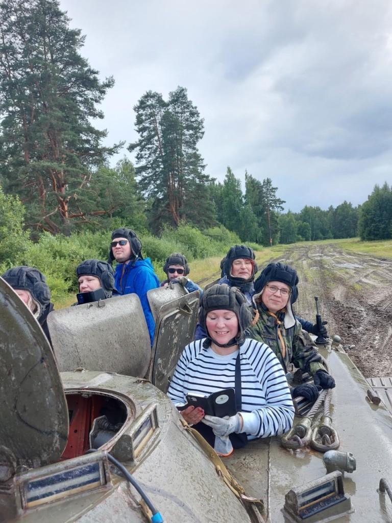 Ihmisiä istuu panssarivaunun kyydissä
