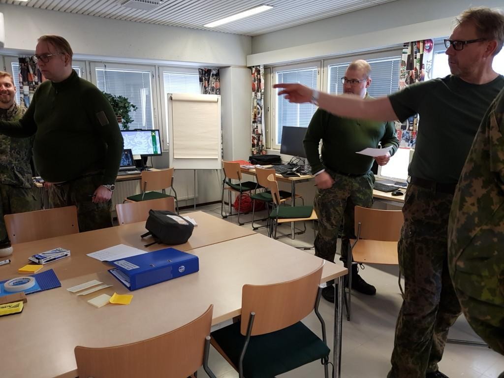Miehiä huoneessa keskustelemassa