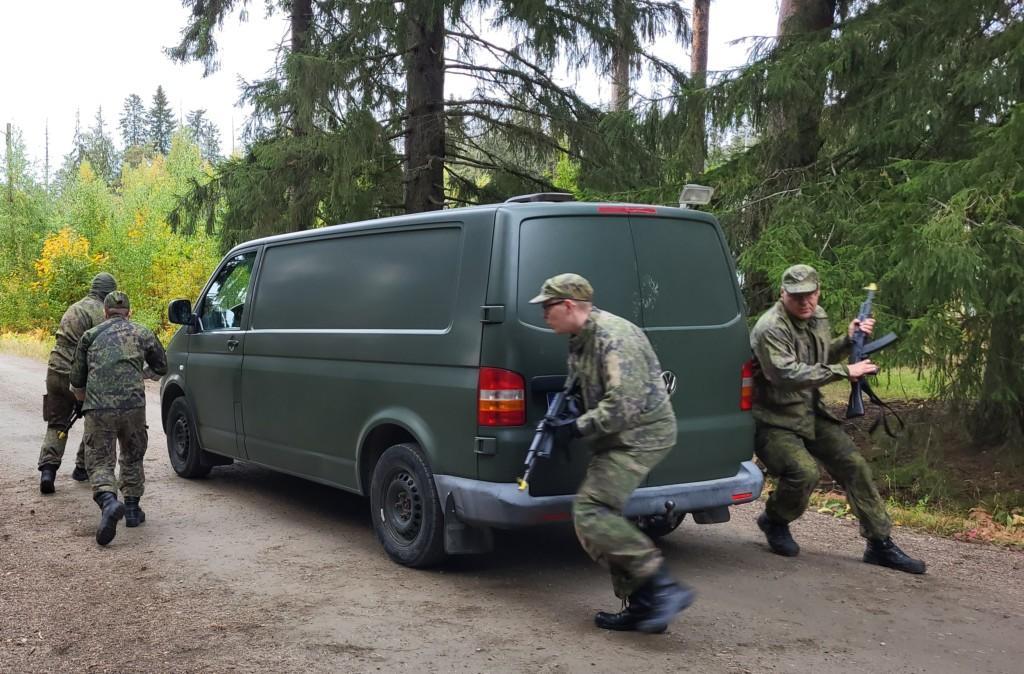sotilaspoliisit harjoittelevat auton ympärillä