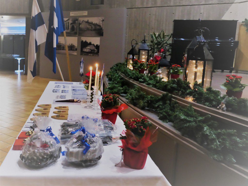 Lahjapöytä, jossa kukkia, kynttilöitä, mitaleja ja lahjoja