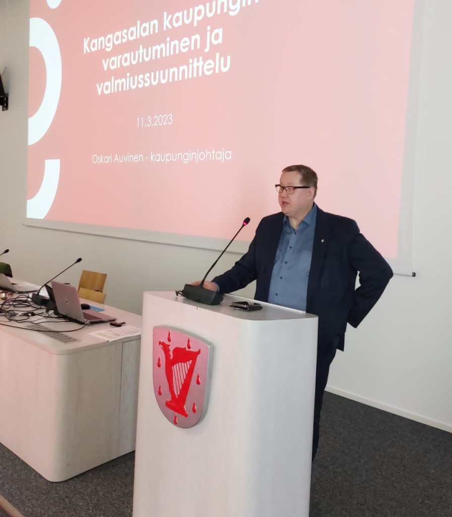Mies pitämässä puhetta puhepöntön takana