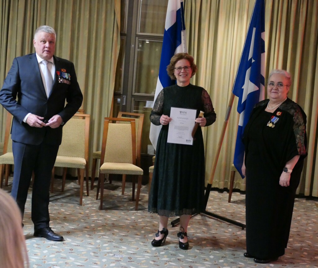 Nainen juhlapuvussa hymyilee