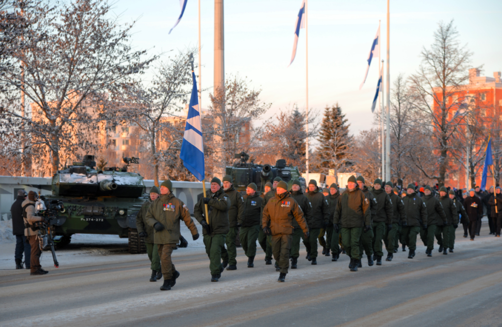 30 MPK-asuista marssijaa panssarivaunun edessä.