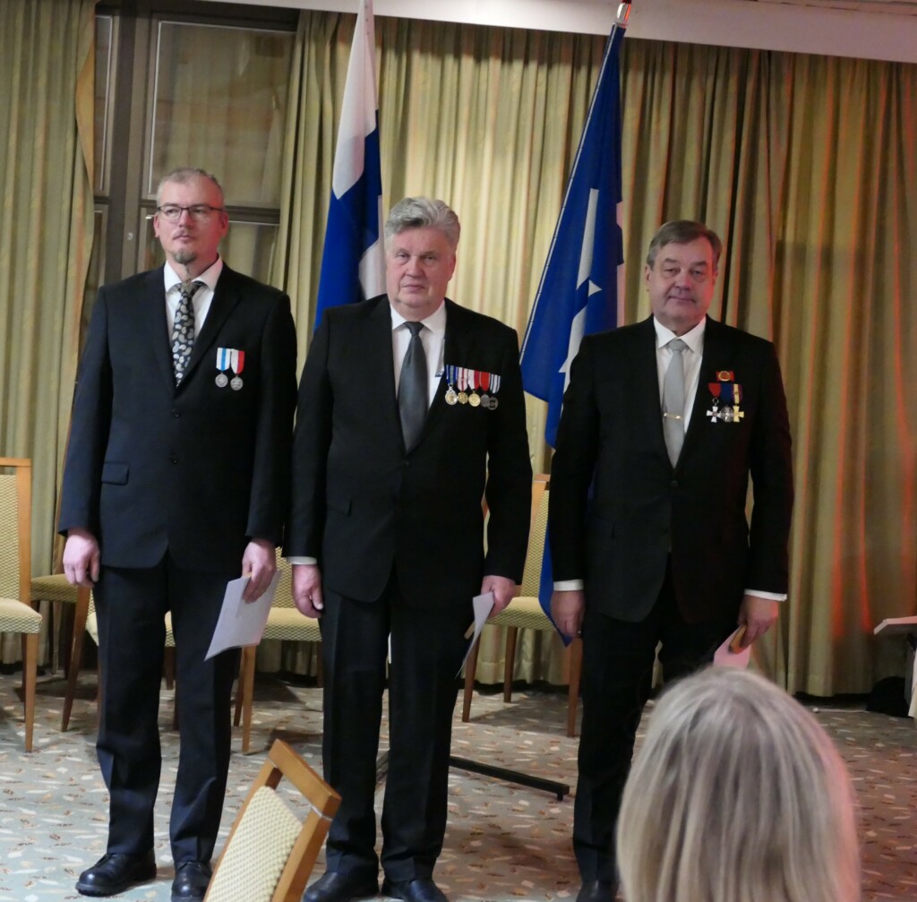 Palkittavat rivissä edessä vastaanottamassa plaketteja