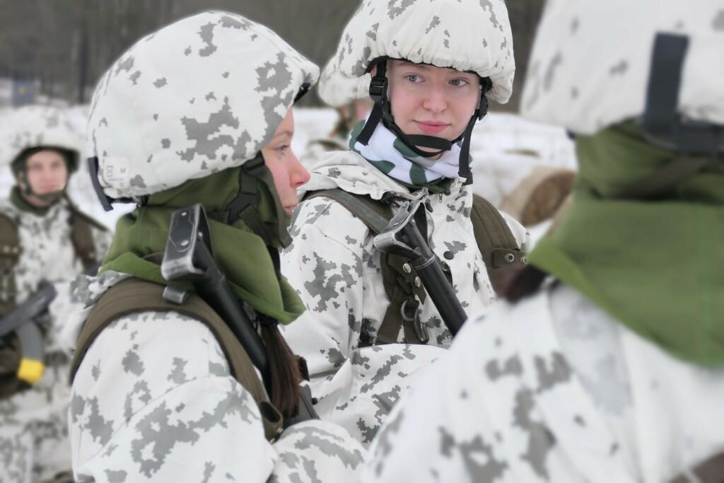 Kaksi nuorta naista talvimaastopuvuissa ulkona.