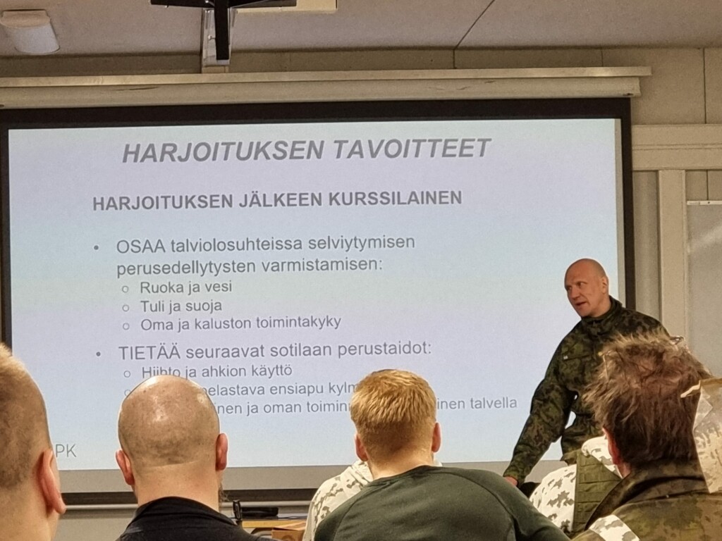 Mies pitää harjoituksen aloituspuhuttelua ihmisten edessä