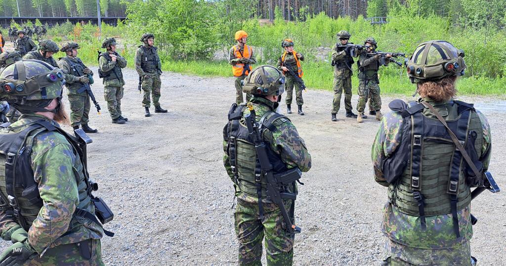 Runsaasti reserviläisiä Puolustusvoimain varusteissa kuuntelemassa ammuntaharjoituksen ohjeita