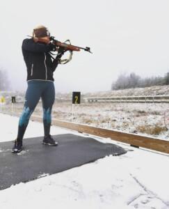 En kvinna skjuter med gevär mot tavlor