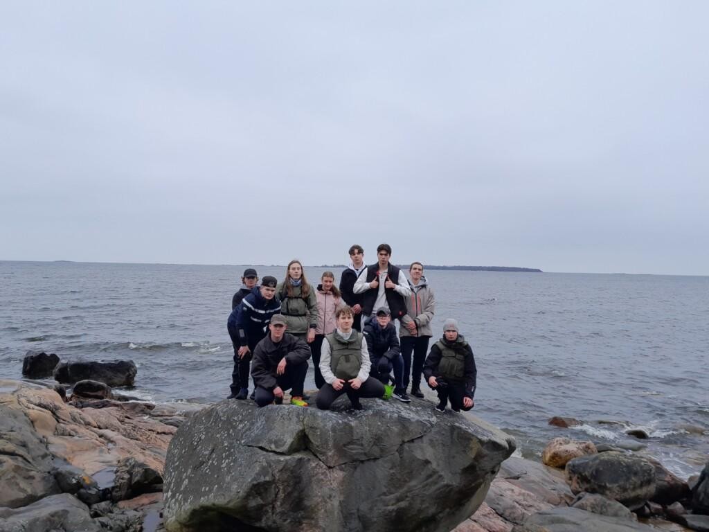 Unga personer på en stor sten vid stranden