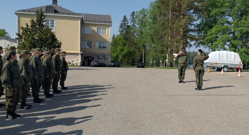 Sotilaspukuisia ihmisiä, kun kurssi ilmoitetaan koulutuspaikan päällikölle.