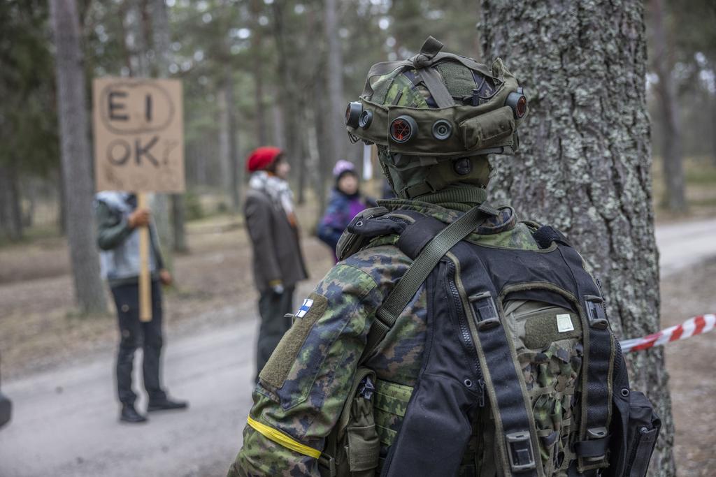 Kuvassa harjoituksessa sotilas ja protestoivia siviilejä.