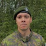 Sotilas maastopuvussa, vihreä baretti päässä.