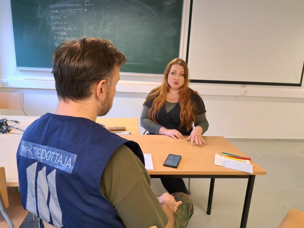 Nainen kertoo miehelle näkemyksiään asiasta molemmat pöydän ääressä istuen