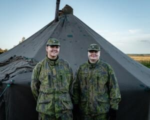 Kuvassa kaksi naista seisoo puolijoukkueteltan edessä
