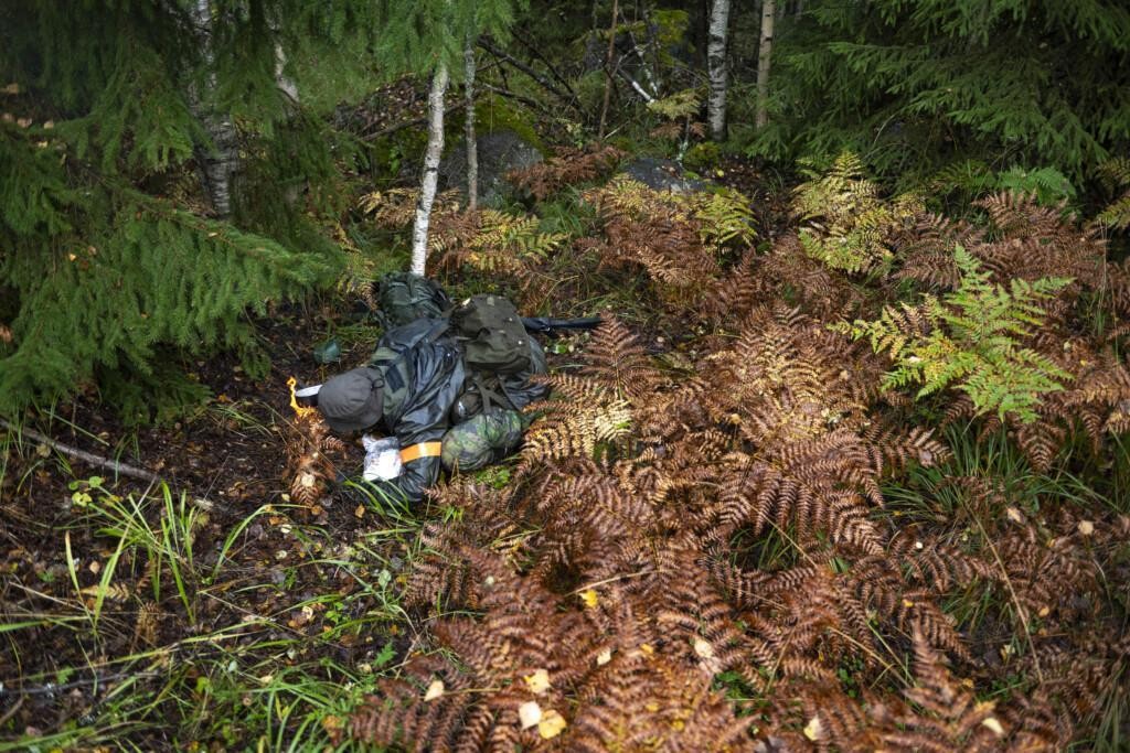 Sotilas maastossa kyykyssä tekemässä nuotiota.