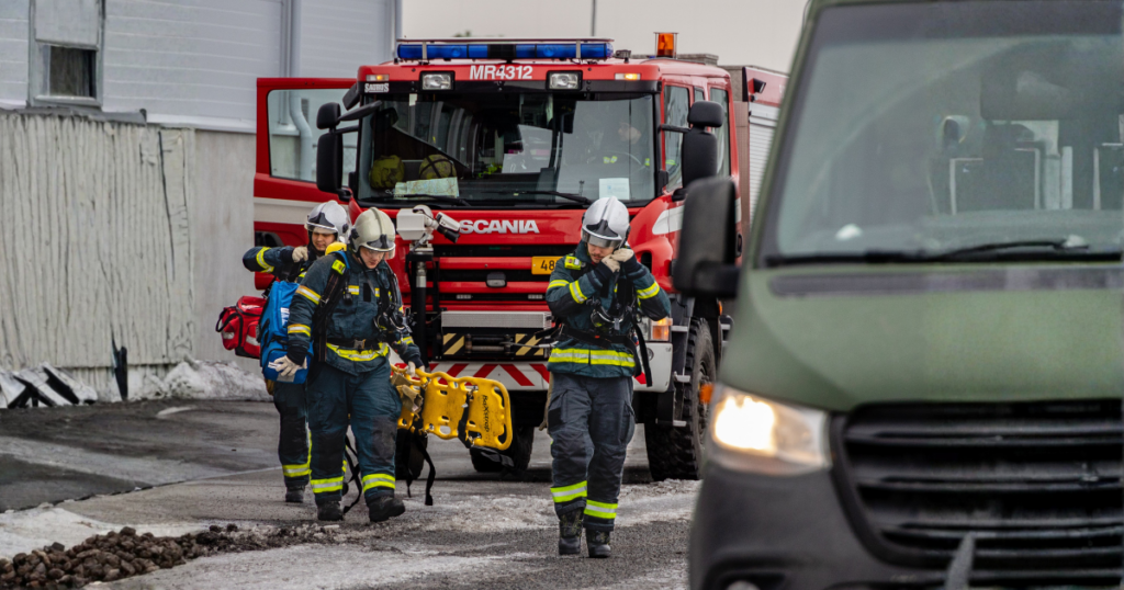 Taustalla Paloauto ja Puolustusvoimien ajoneuvo