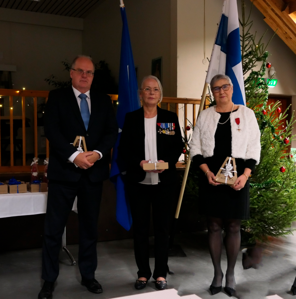 Ihmisiä juhlapuvuissa rivissä palkitsemistilaisuudessa.
