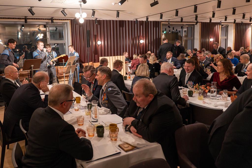 Juhlijoita vuosijuhlassa, varusmiesbändi soittamassa juhlijoille