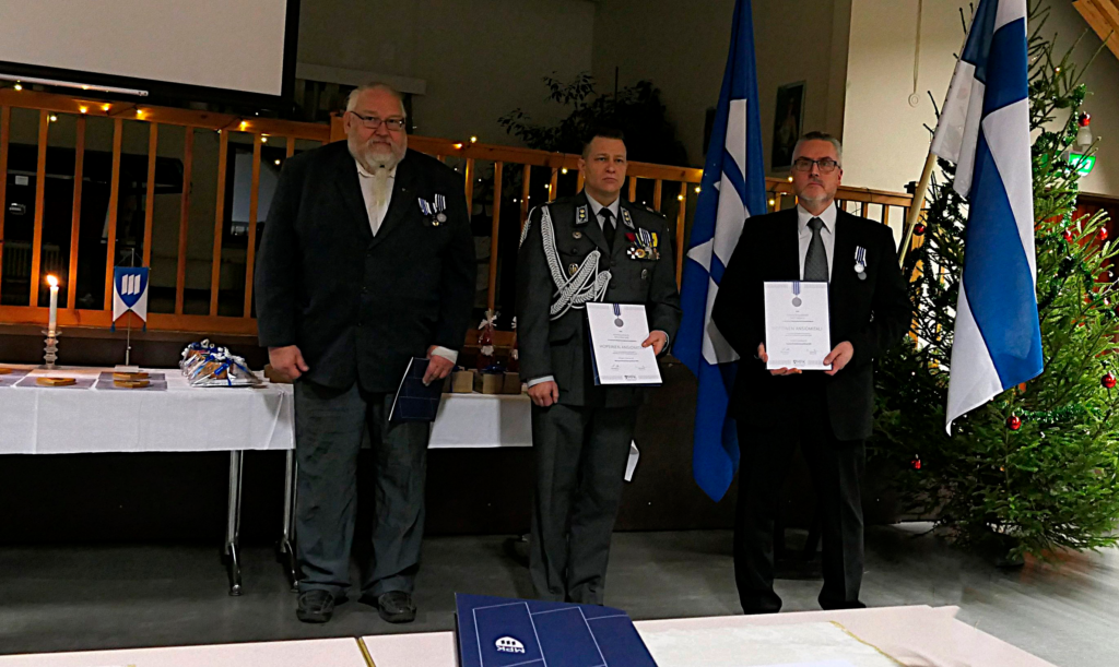 Ihmisiä juhlapuvuissa palkitsemistilaisuudessa