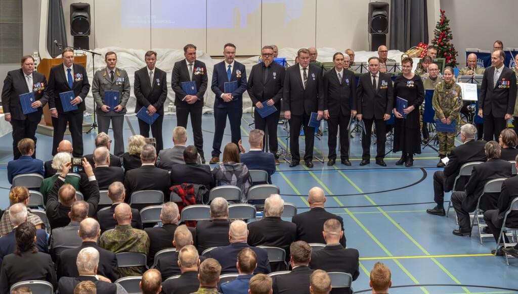 Paljon ihmisiä juhlapuvuissa yleisön edessä palkitsemistilaisuudessa