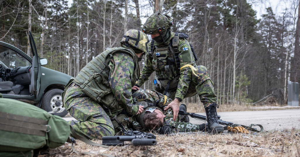 Kaksi sotilasta hoitaa kolmatta kenttälääkinnän harjoituksessa