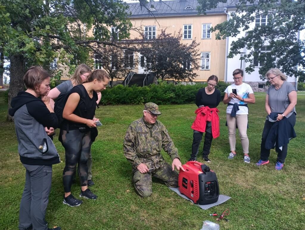 Ihmisiä nurmikolla tarkastelemassa aggregaattia