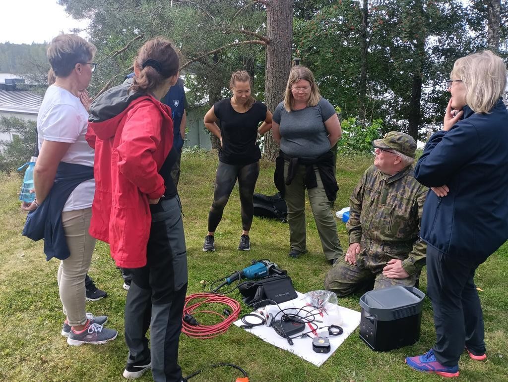 Ihmisiä nurmikolla tutustumassa aggregaatin toimintaan
