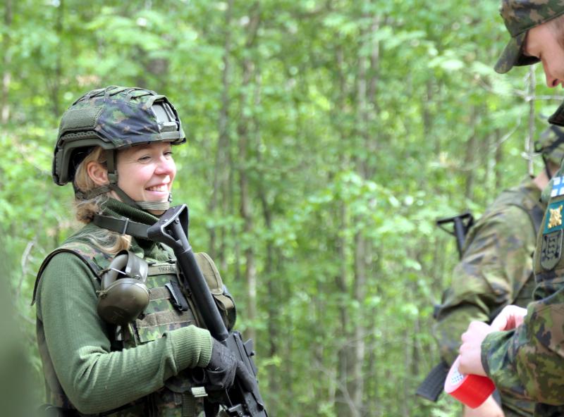 Kuvassa kaksi maastopukuista henkilöä keskustemassa.